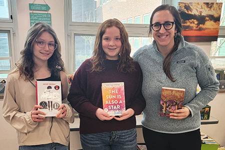 Students and Ms. Chambers show off their favorite books as part of book club